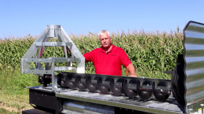Sudenga engineer Cory Vaselaar standing next to the Sudenga Grain Halo Sump Guard