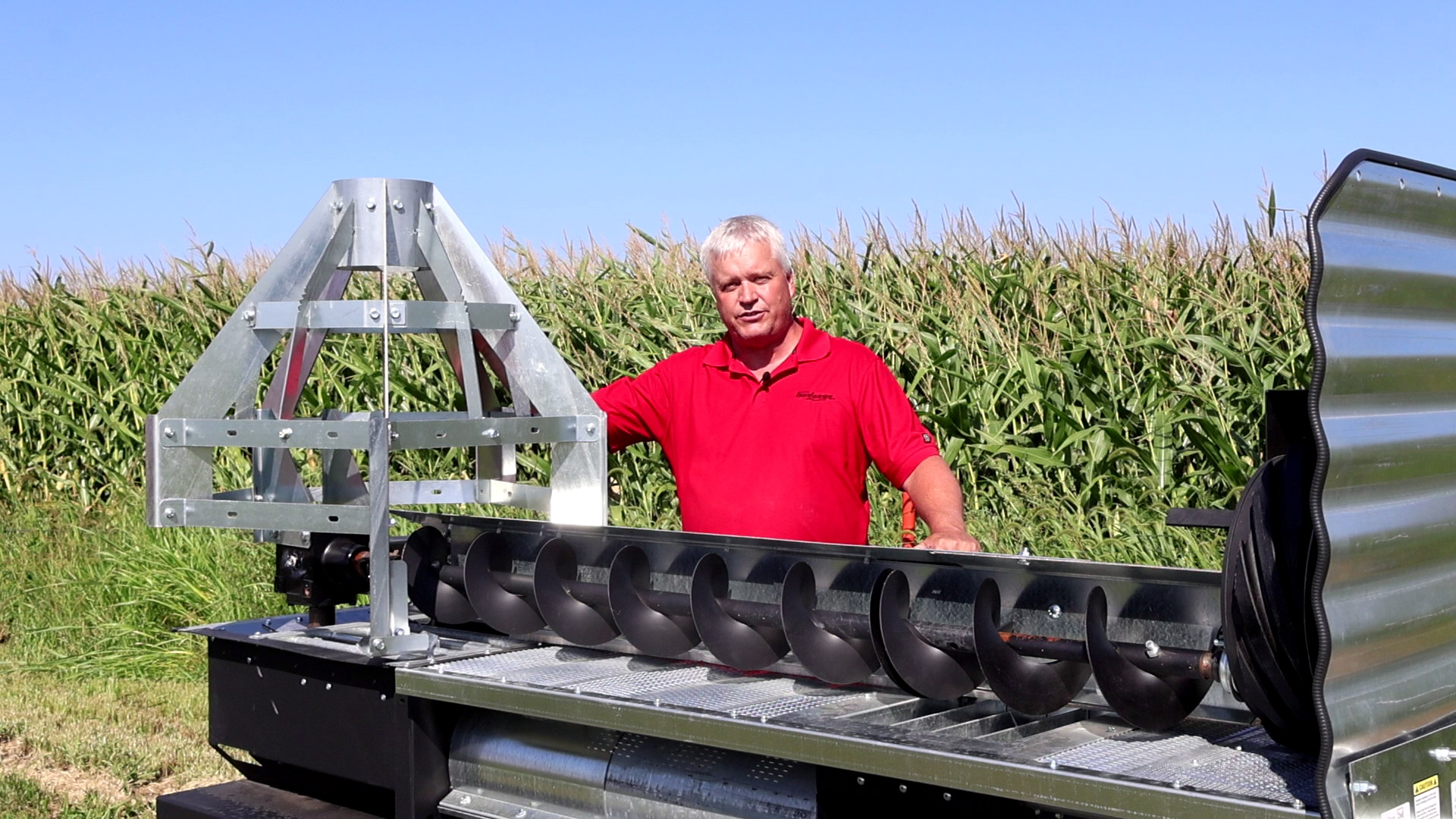 Sudenga engineer Cory Vaselaar standing next to the Sudenga Grain Halo Sump Guard